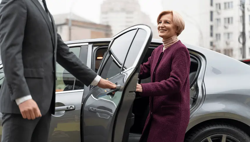 Limousine service representative helping client with luggage